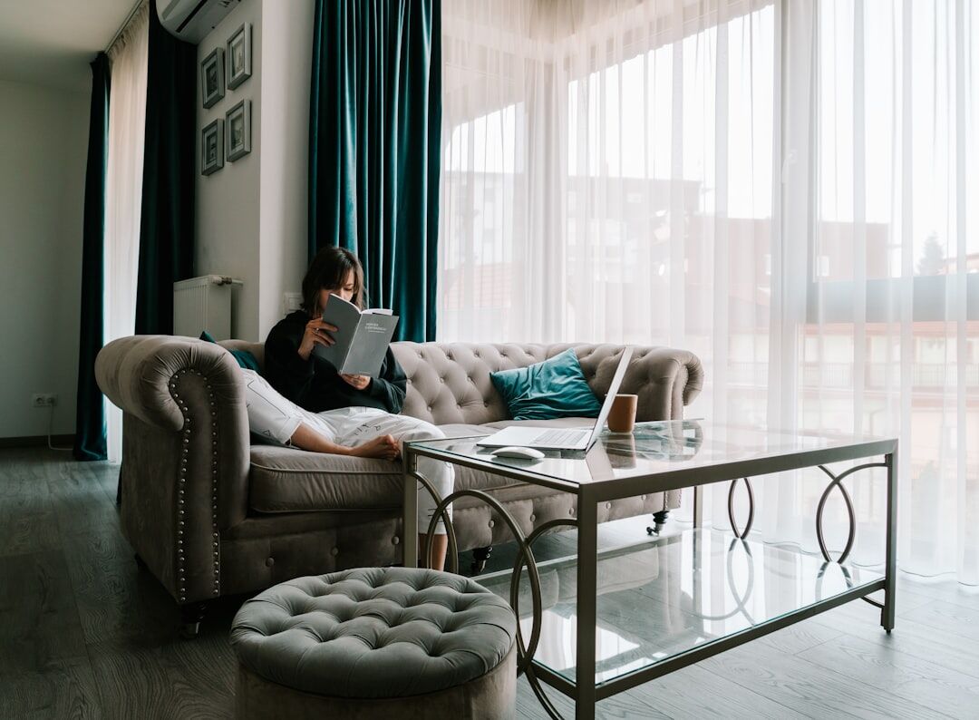 Senior woman reading a newspaper at home by the window