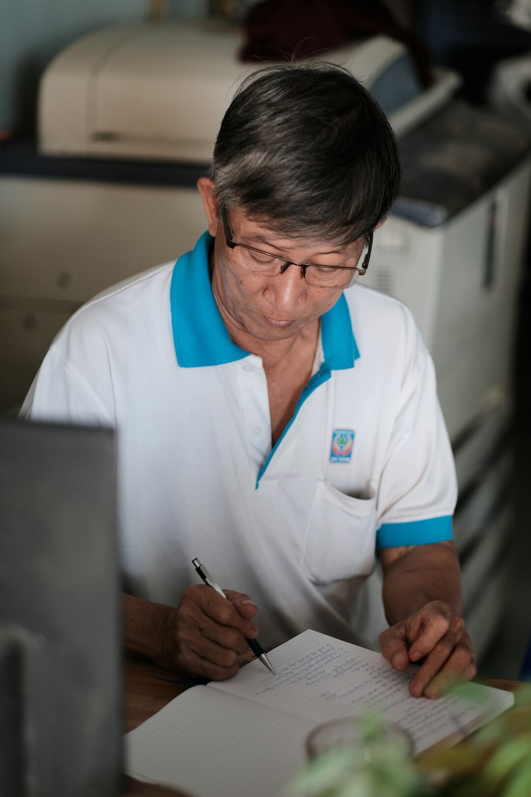 Friendly staff member helping a senior woman with registration at a community desk