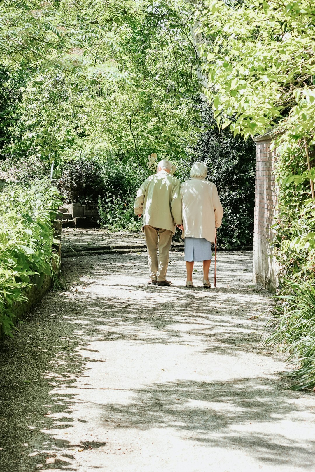 Smiling senior couple walking together in a sunny park in Slovakia